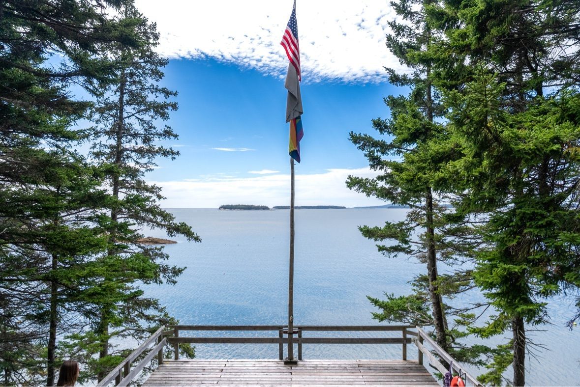 Wooden deck overlooking a lake with an American flag
